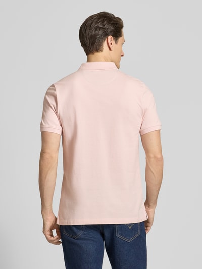 Männermodel trägt Regular Fit Poloshirt aus reiner Baumwolle von s.Oliver RED LABEL in Rosa, unifarben, Piqué-Textur, Ganzkörperansicht Rückansicht.