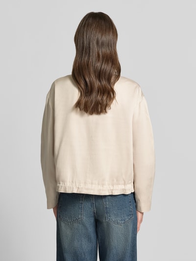 Frauenmodel trägt Jacke aus Lyocell-Baumwoll-Mix Modell 'Jarusa' von OPUS in Beige, Relaxed-Fit, Stehkragen mit Tunnelzug, Reißverschluss, Rückenlänge 56 cm, Schulterbreite 54 cm, Brustweite 57 cm, Ärmellänge 53 cm, Ganzkörperansicht Rückansicht.