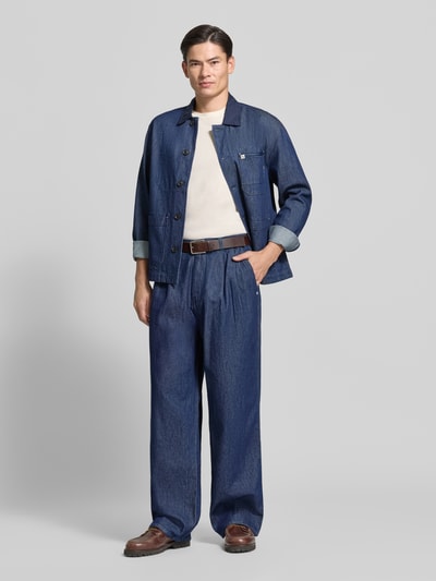 Männermodel trägt Loose Fit Jeans mit Eingrifftaschen von Scotch & Soda in Dunkelblau, Baumwoll-Lyocell-Mix, Ganzkörperansicht von vorne.