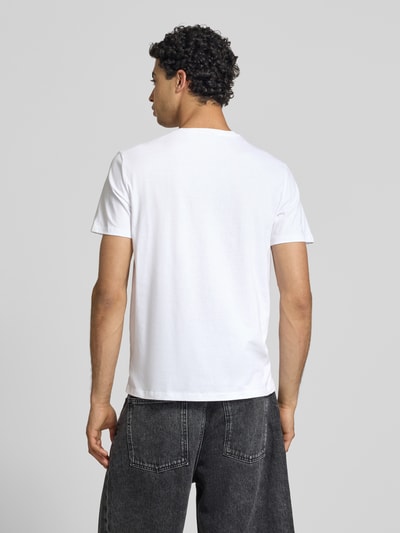Męski model nosi T-Shirt mit Label-Badge von Calvin Klein Jeans, biała bawełna, krój regular fit, okrągły dekolt, długość tyłu 70 cm, Ganzkörperansicht Rückansicht.