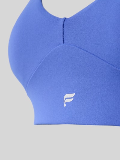 Frauenmodel trägt Bustier mit Label-Print Modell 'PURELUXE LONGLINE' von Fabletics in Blau, Elastischer-Material-Mix, Nahaufnahme Oberkörper.