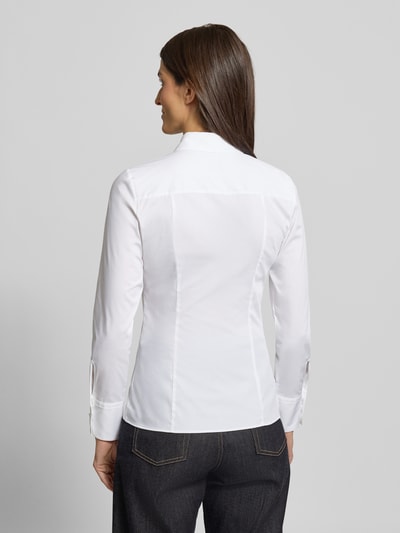 Frauenmodel trägt weiße Hemdbluse mit 3-Knopf-Manschetten Modell 'The Fitted' von HUGO aus Baumwollmischung mit Stretch-Anteil, taillierter Schnitt, Umlegekragen, Knopfleiste, Rückenlänge 62 cm, Ärmellänge 61 cm, Ganzkörperansicht Rückansicht.