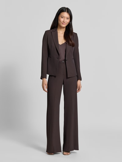 Vrouwenmodel draagt Slim Fit Blazer met reverskraag van Rinascimento in donkerbruin, met knoopsluiting en paspelzakken, slim fit, ruglengte maat S 56 cm, volledige lichaamsvooraanzicht.
