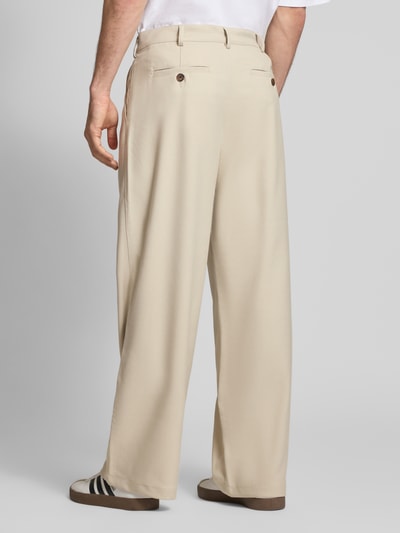 Männermodel trägt Wide Leg Hose mit Eingrifftaschen von PROHIBITED in Beige, Material-Mix mit Viskose-Anteil, Ganzkörperansicht Rückansicht.