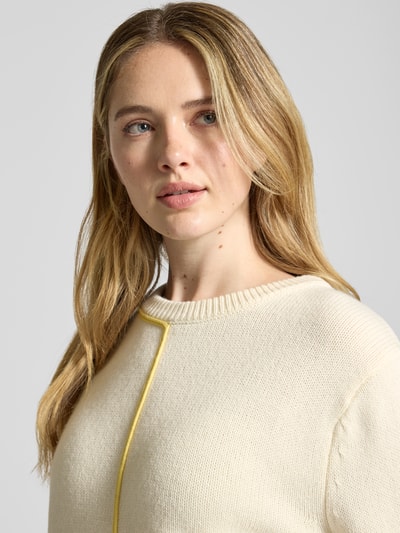 Vrouwenmodel draagt Relaxed fit gebreide pullover met wol, model 'JANIQUE' van Guido Maria Kretschmer, materiaalmix, ronde hals, crèmekleur, detailopname bovenlichaam