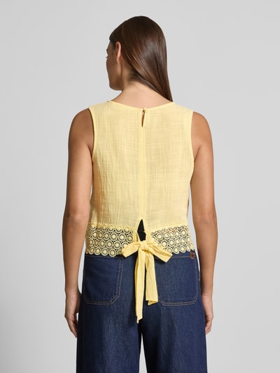 Frauenmodel trägt Regular Fit Top mit Lochstitching von Apricot in Gelb aus Reine Baumwolle mit Zierschleife, Ärmelloses-Design, Rückenlänge 46 cm, Ganzkörperansicht Rückansicht.
