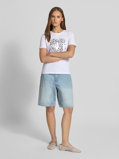 Frauenmodel trägt Regular Fit T-Shirt aus reiner Baumwolle Modell 'KITA' von ONLY in Weiß mit Leopardenkopf-Print, Damen T-Shirt von ONLY, Ganzkörperansicht von vorne.