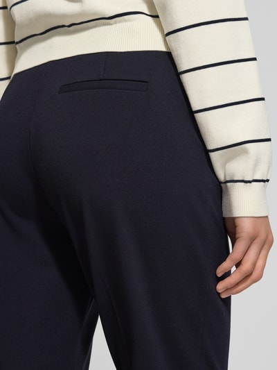 Frauenmodel trägt Stoffhose mit Gesäßtasche von Comma aus Viskose-Mix mit Stretch-Anteil, lässiger Schnitt, Nahaufnahme Oberkörper.