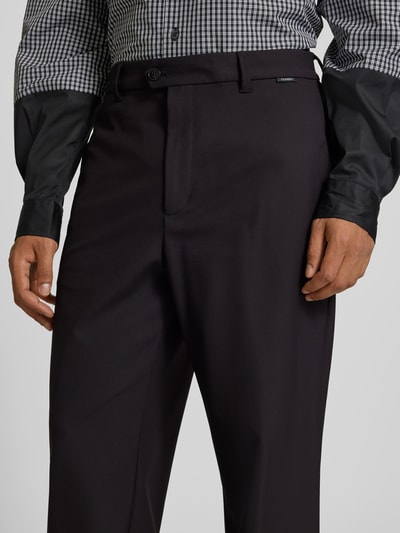 Männermodel trägt Straight Fit Anzughose mit Bügelfalten von Closed, dunkle Farbe, Elastischer-Material-Mix, Eingrifftaschen, Nahaufnahme Oberkörper.