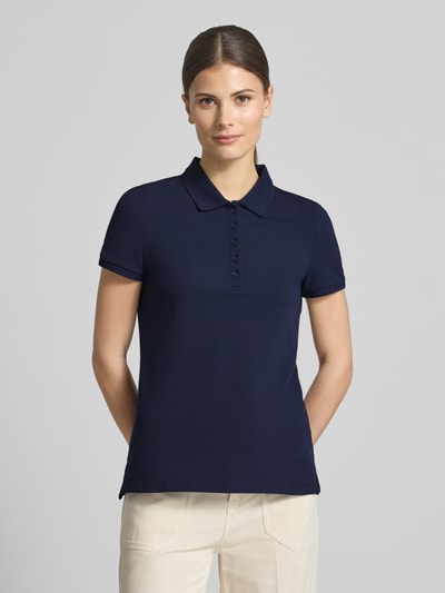 Frauenmodel trägt Slim Fit Poloshirt mit Knopfleiste von Christian Berg Woman, dunkelblau, Baumwoll-Elasthan-Mix, Seitenschlitze, Rückenlänge bei Größe S 62 cm, Nahaufnahme Oberkörper.