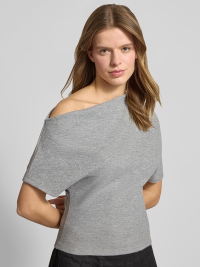 Frauenmodel trägt Regular Fit T-Shirt im asymmetrischen Design von Gina Tricot, grauer Baumwoll-Material-Mix, kurzärmelig, Nahaufnahme Oberkörper. Rückenlänge bei Größe S: 60 cm.