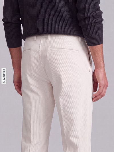 Männermodel trägt Relaxed Fit Cordhose aus Baumwoll-Mix Modell 'Lui_2V-D' von Strellson in Creme, Struktur mit feinem Cord, Ganzkörperansicht Rückansicht, Herren Cordhose von Strellson, KI-modifiziertes Bild.