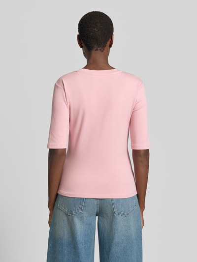 Frauenmodel trägt T-Shirt mit Rundhalsausschnitt von Christian Berg Woman aus Baumwoll-Elasthan-Mix, Slim-Fit, 1/2-Arm, Rückenlänge 53 cm, hellrosa Farbe, glatte Struktur, Ganzkörperansicht Rückansicht.