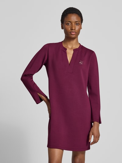 Vrouwenmodel draagt Regular fit mini-jurk uit viscosemix Model 'Abito' van Liu Jo met siersteentjes, met lange mouwen, serafinohals, bordeauxrood, rechte lijnen, zachte textuur, details ruglengte 88 cm, borstwijdte 50 cm, mouwlengte 61 cm, full body frontaal.