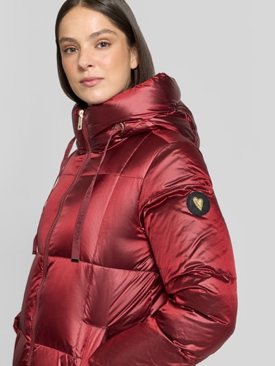 Frauenmodel trägt Mantel mit Entenfederfüllung Modell 'Nova' von MOS MOSH in Rot mit Stehkragen, Zweiwege-Reißverschluss, Nahaufnahme Oberkörper.