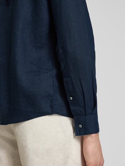 Männermodel trägt Regular Fit Freizeithemd aus reinem Leinen von s.Oliver RED LABEL in Dunkelblau, glatte Textur, Detailaufnahme rechter Ärmel.