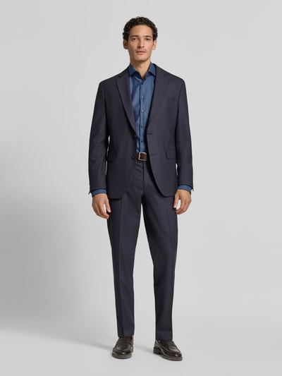 Männermodel trägt Slim Fit Businesshemd in Premiumqualität mit extra langem Arm von Jake*s, dunkelblau mit diagonalen Nadelstreifen, Allover-Muster, Kentkragen, hochwertige Verarbeitung, reine Baumwolle, Ganzkörperansicht von vorne.