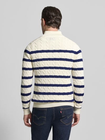 Mannelijk model draagt Slim Fit Pullover in Strick-Optik van Gant, katoen, troyer-kraag, logo-stiksel, witte en blauwe strepen, achteraanzicht.