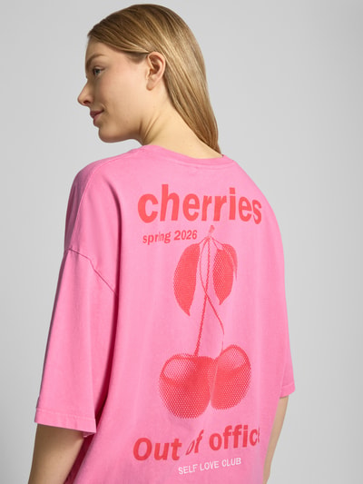 Frauenmodel trägt T-Shirt mit rückseitigem Motiv-Print Modell 'NICA' von ICHI in Pink, aus Baumwolle, Statement-Print, Ganzkörperansicht Rückansicht