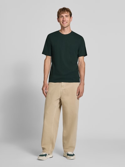 Männermodel trägt t-shirt met rechte model van JACK & JONES, puur katoen, ronde hals, ruglengte bij maat M 68 cm, Model 'ORGANIC', ganzlichaamsaanzicht van voren.