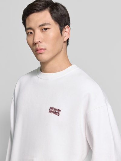 Männermodel trägt Sweatshirt mit Logo Modell 'PLIZZY' von American Vintage in Weiß, Reine Baumwolle, Relaxed-Fit, Rundhalsausschnitt, Nahaufnahme Oberkörper.
