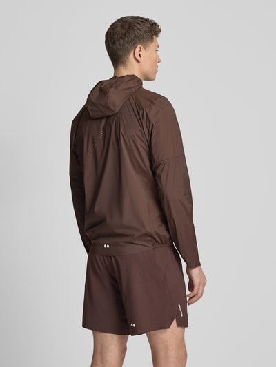 Männermodel trägt Windbreaker mit Kapuze und Logo Modell 'SENSE AERO' von Salomon, Material-Mix mit Stretch-Anteil, Regular-Fit, Rückenlänge 71 cm, Schulterbreite 44 cm, Brustweite 41 cm, Ärmellänge 67 cm, einfarbig braun, glatte Textur, Ganzkörperansicht Rückansicht.