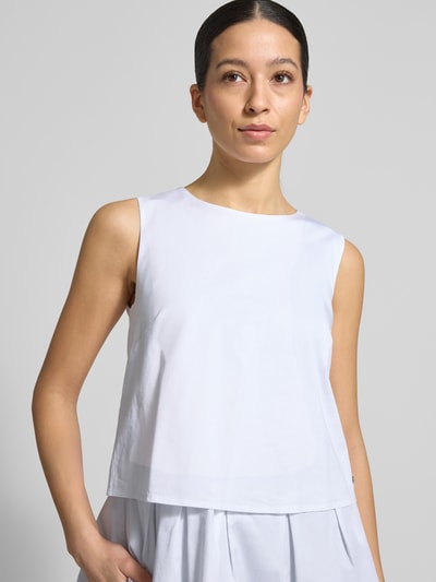 Modelka prezentuje Blusenshirt mit Volantsaum und Rundhalsausschnitt von Marc Cain, mieszanka bawełny i wiskozy, prosty krój, okrągły dekolt, dół obszyty falbaną, zamek błyskawiczny z tyłu, długość tyłu w rozmiarze 36: 59 cm, jasne kolory, gładka tekstura, ujęcie: zbliżenie na górną część ciała.