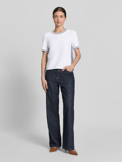 Frauenmodel trägt Strickshirt mit Kontraststreifen von Marc Cain, weiß mit blauen Details, Baumwoll-Mix, Regular-Fit, Rundhalsausschnitt, Rückenlänge 44 cm, Ärmellänge 23 cm, Ganzkörperansicht von vorne.