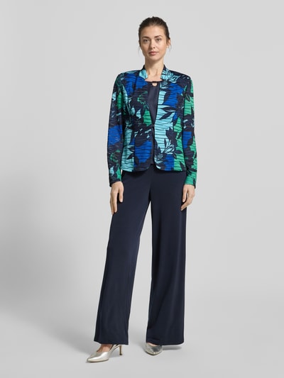 Modelka nosi Slim Fit Blazer im Allover-Look od Vera Mont w kolorach niebieskim, zielonym i czarnym, materiał z domieszką stretchu, stojący kołnierz, długość pleców w rozmiarze 36: 60 cm, krój slim fit, widok całej sylwetki z przodu.