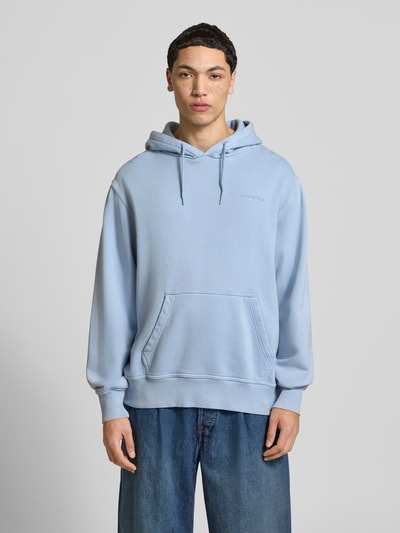 Männermodel trägt Hoodie mit Label-Stitching und Känguru-Tasche von Dickies in Hellblau, Baumwoll-Mix, Relaxed Fit, Ganzkörperansicht von vorne.
