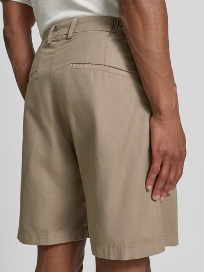 Männermodel trägt Shorts mit Gesäßtaschen Modell 'YASAN' von Drykorn, Beige, Leinen-Baumwoll-Mix, Regular-Fit, Ganzkörperansicht Rückansicht. Bundweite Größe 32: 45 cm, Innenbeinlänge: 50 cm.