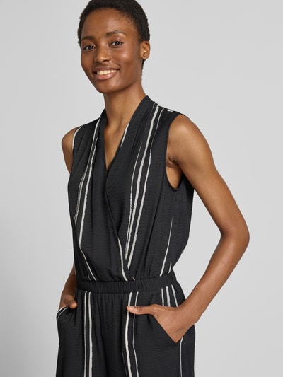 Vrouwenmodel draagt Jumpsuit aus Viskose-Mix im Allover-Look Modell 'Cafalli' van someday, zwart met witte strepen, regular fit, allover look, wikkeloptiek, viscosemix, borstwijdte 50 cm bij maat 36, totale lengte 136 cm, binnenbeenlengte 63 cm, detailopname bovenlichaam.