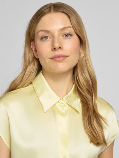 Frauenmodel trägt Regular Fit Bluse aus Seide mit Knopfleiste von Luisa Cerano in hellem Gelb, seidige glatte Textur, Nahaufnahme Oberkörper.