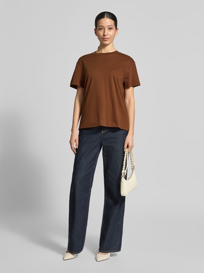 Frauenmodel trägt T-Shirt mit Rundhalsausschnitt von Stefanel in Braun, reine Baumwolle, gerader Schnitt, kombiniert mit Jeans, Ganzkörperansicht von vorne.