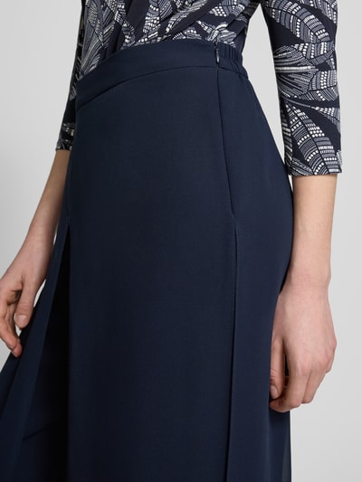 Kobiece modelka nosi Wide Fit Stoffhose im semitransparentem Design od Vera Mont, półprzezroczysty materiał, krój wide fit, kopertowy styl, wszyty zamek błyskawiczny, szerokość w rozmiarze 36: 29 cm, długość wewnętrzna nogawki w rozmiarze 36: 86 cm, granatowy kolor, gładka tekstura, zdjęcie w zbliżeniu na okolice biodra