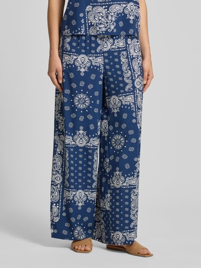 Frauenmodel trägt Relaxed Fit Weite Hose aus reiner Viskose Modell 'KAVI' von Only in Dunkelblau mit weißem Muster, Ganzkörperansicht von vorne. Damen Weite Hose.