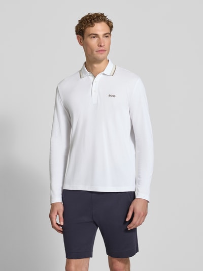 Männermodel trägt weißes Regular Fit Poloshirt aus reiner Baumwolle Modell 'Plisy' von BOSS, dezenter Logo-Schriftzug, Ganzkörperansicht von vorne, Herren Poloshirt von BOSS.