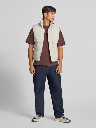 Mannenmodel draagt bodywarmer met opstaande kraag, regular fit, Model 'SOHO BODYWARMER' van JACK & JONES, lichte beige kleur, voorkant, productdetails: ritssluiting onzichtbaar, Ruglengte maat M 65 cm, Schouderbreedte 43 cm, Borstwijdte 59 cm, Ganzkörperansicht van voren.