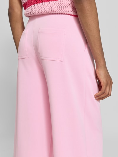 Frauenmodel trägt Wide Leg Sweatpants aus Modal-Mix von Rich & Royal in zartrosa mit Gesäßtaschen, Nahaufnahme Rückansicht.