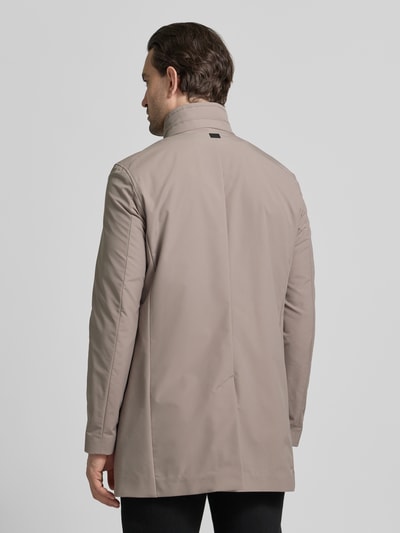 Männermodel trägt Regular Fit Kurzmantel mit Stehkragen Modell 'FYNN' von Strellson, beige Twill, unifarben, Ganzkörperansicht Rückansicht.