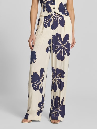 Frauenmodel trägt Stoffhose im Allover-Look Modell 'DOTTER' von MANGO, creme mit dunkelblauem Blumenmuster, Lyocell-Mix, Wide Leg, Ganzkörperansicht von vorne.