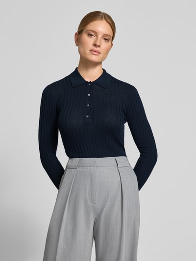 Vrouwenmodel draagt donkerblauw poloshirt van Style Icon Collection van puur katoen, skinny fit, riblook, met lange mouwen, tricotlook. Nahaufnahme Oberkörper.