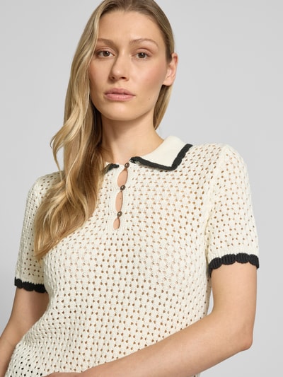Vrouwenmodel draagt Slim Fit Poloshirt in Strick-Optik van Jake*s Casual, wit met zwart, katoen, structuur, polokraag, korte mouw, detailopname bovenlijf.