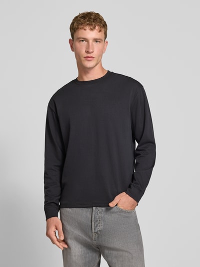 Männermodel trägt Relaxed Fit Langarmshirt aus Baumwoll-Mix Modell 'SCASPIAN' von ONLY in Dunkelgrau, Herren T-Shirt, Ganzkörperansicht von vorne.