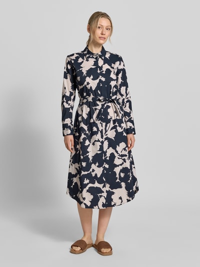 Kobiece modelka nosi 'Hemdblusenkleid im Allover-Look mit Bindegürtel' od comma, mieszanka bawełny z dodatkiem streczu, linia a, sukienka midi, wzór na całej powierzchni, wiązany pasek, długość tyłu w rozmiarze 36: 120 cm, szerokość w rozmiarze 36: 49 cm, długość rękawów w rozmiarze 36: 60 cm, granatowo-beżowy motyw, gładka tekstura, widok całej sylwetki z przodu.
