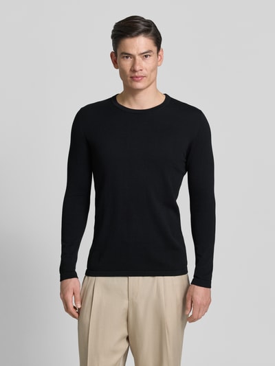 Männermodel trägt Slim Fit Pullover in Strick-Optik Modell 'Mino' von Drykorn in Schwarz, Rundhalsausschnitt, Ganzkörperansicht von vorne, reine Baumwolle