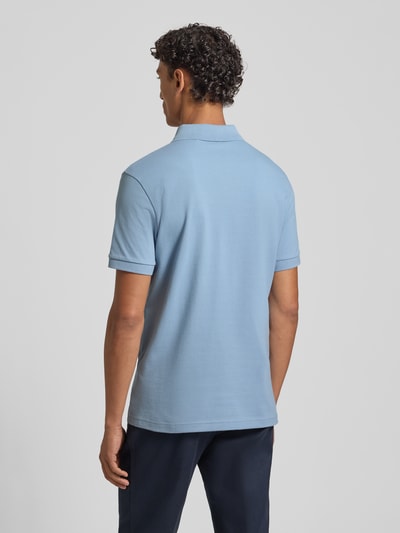 Männermodel trägt Regular Fit Poloshirt aus Baumwoll-Mix Modell 'PASSENGER' von BOSS Orange in Optik: Unifarben mit gerippter Ärmelabschluss, Materialverarbeitung: Piqué, Ganzkörperansicht Rückansicht.