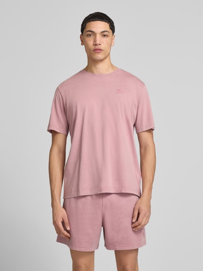 Männermodel trägt T-Shirt mit Label-Stitching und Rundhalsausschnitt von CHAMPION in Rosa, Reine Baumwolle, Regular-Fit, Ganzkörperansicht von vorne, Rückenlänge bei Größe M 67 cm.