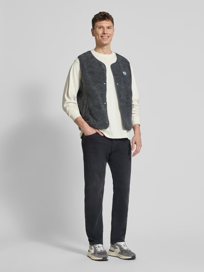Mannenmodel draagt Straight Fit Weste met logo-patch model 'Hoktown' van American Vintage in kunstbont, ronde hals, knoopsluiting, voorkant volledig lichaam.