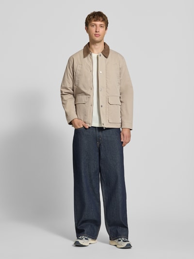 Mannenmodel draagt Regular Fit Jacke in Stiksels van JACK & JONES, beige met corduroy Platte kraag, opgestikte zakken, logopatch, Ganzkörperansicht von vorne. Ruglengte maat M: 72 cm, schouderbreedte: 49 cm, borstwijdte: 59 cm, mouwlengte: 65 cm.